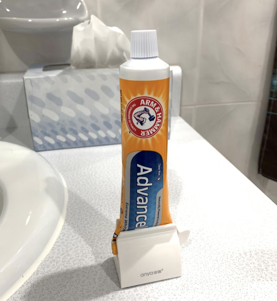 reviewer photo of the white holder with toothpaste inside