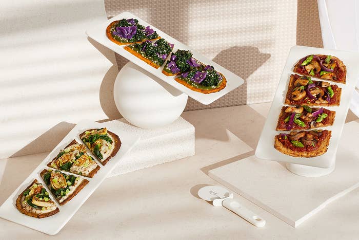Three flatbreads covered in colorful vegetables.