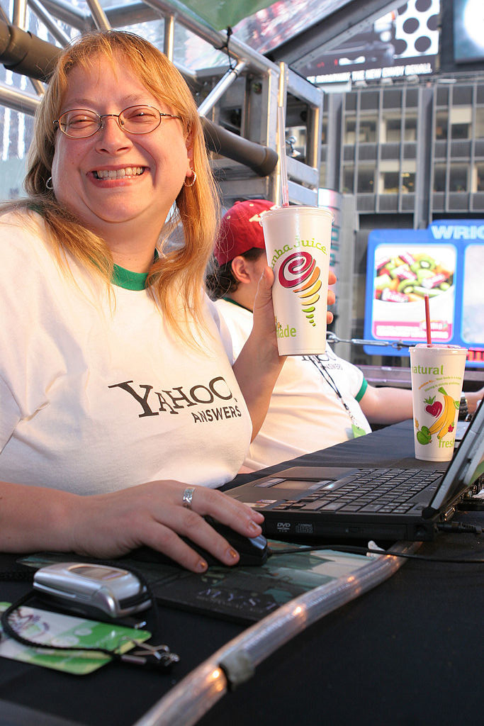 A employee smiling and holding her Jamba Juice while wearing a Yahoo Answers ringer tee.