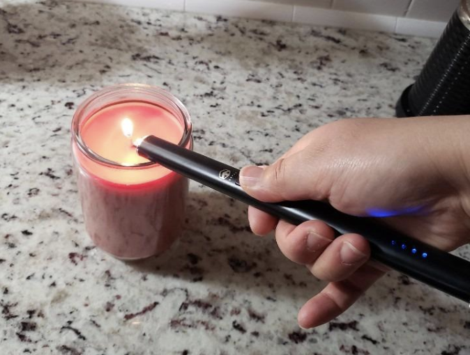 A reviewer lighting a candle with the lighter 