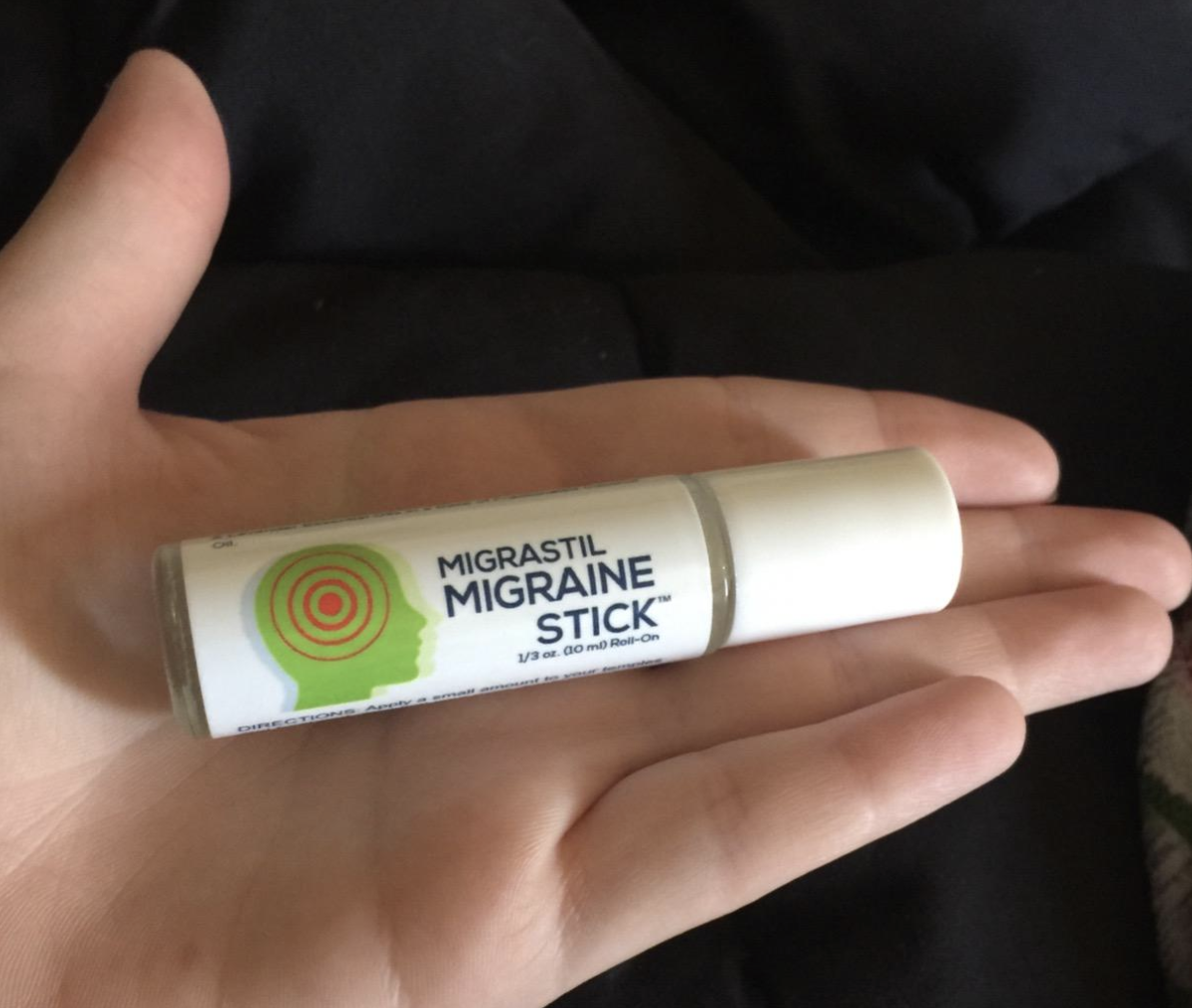 A reviewer holding the small balm-sized roller stick 
