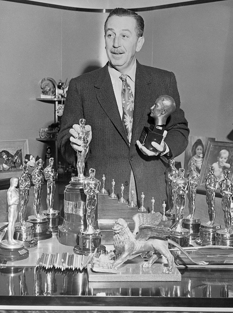 Walt Disney at his desk with his Oscars