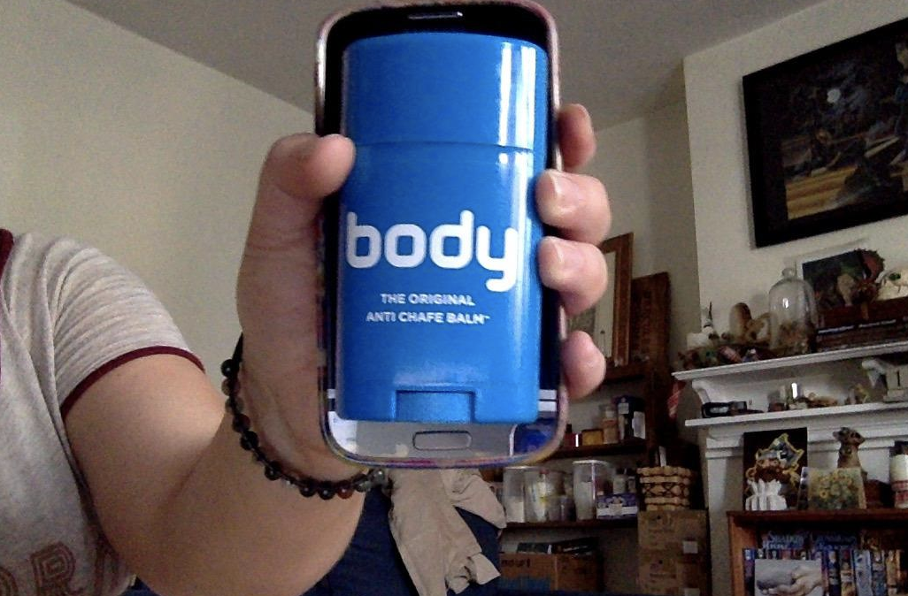 Reviewer holds a blue anti-chafe balm container that says &quot;body The Original Anti-Chafe Balm&quot;