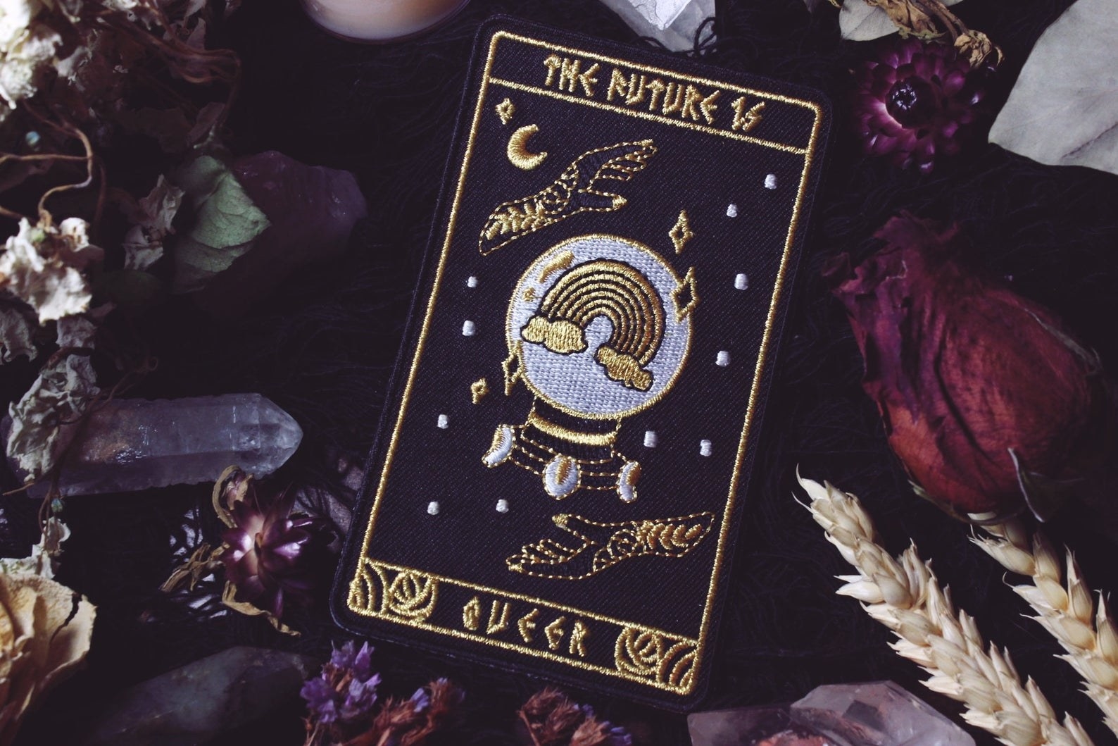 clothing patch with stars, hands, rainbow, and "the future is queer"