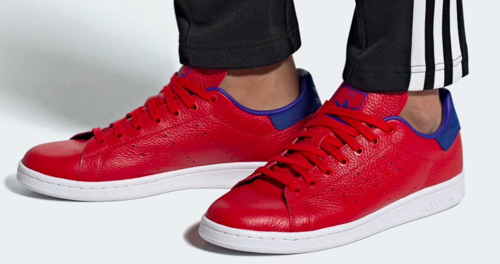 Red sneakers the color of a bold red lipstick with matching red laces, and a pop of royal blue on the heal lip