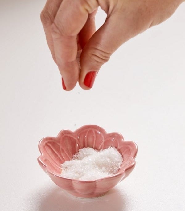 A flower shaped pinch bowl filled with salt