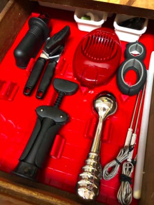 a reviewer photo of the inside of a drawer customized to fit a variety of different kitchen tools