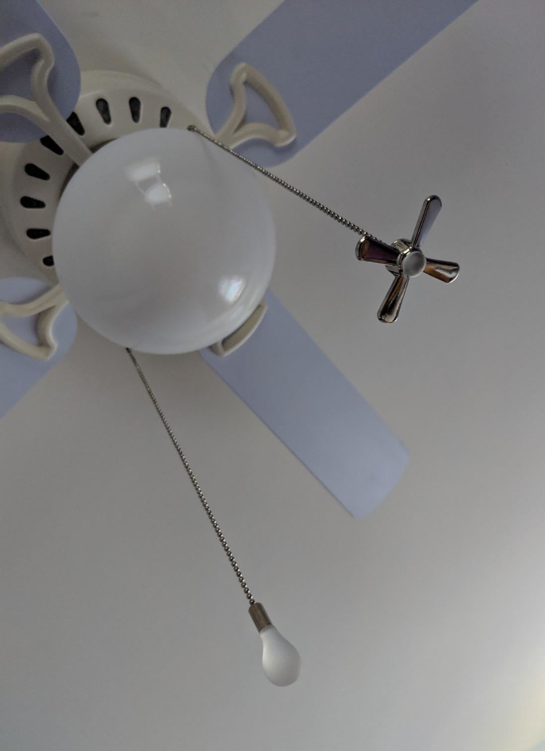 a reviewer&#x27;s photo of the fan and light bulb chains hanging from a ceiling fan