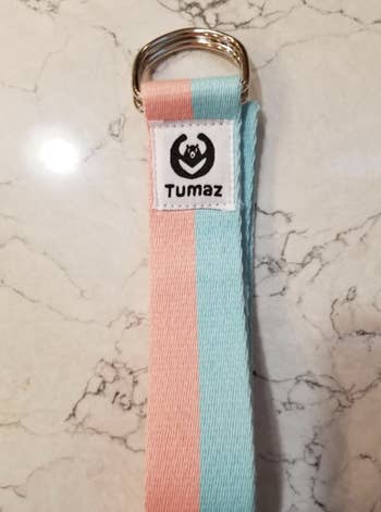 two-tone blue and baby pink yoga strap on marble surface