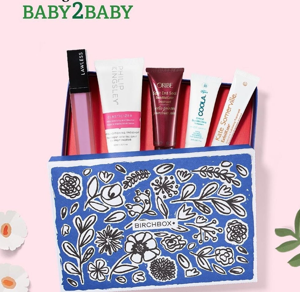 A blue floral Birchbox box with five samples peeking out from it, including a lipgloss and several skincare products.