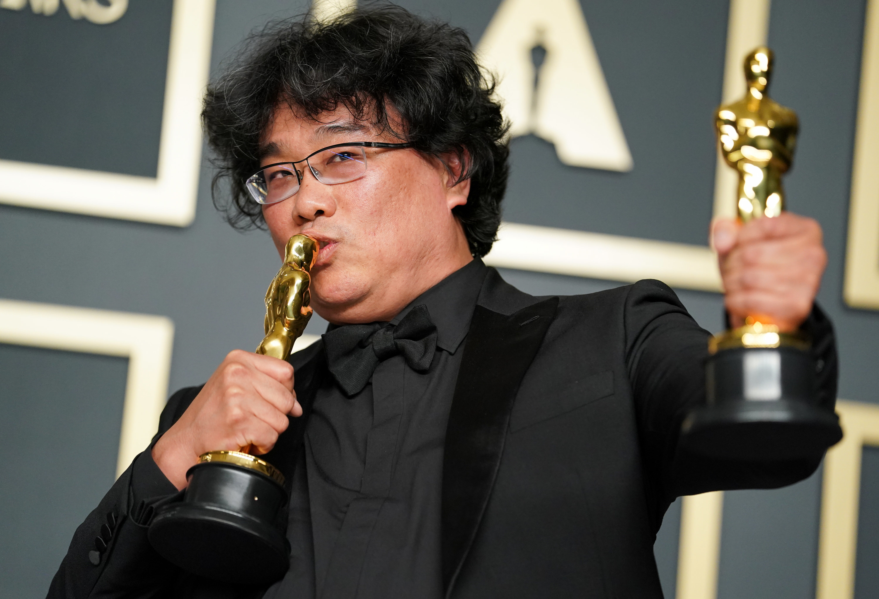 Bong Joon-ho kissing one of his two Oscars