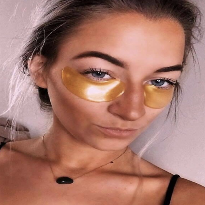 someone posing with the gold under-eye masks on
