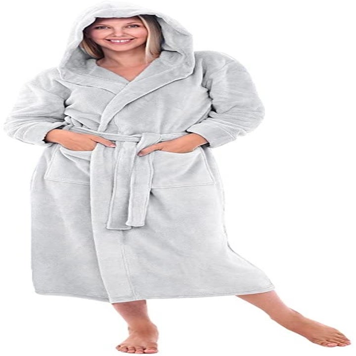 a model wearing an all grey robe with the hood up