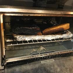 A reviewer's heavily burned toaster oven with a charred  bagel inside