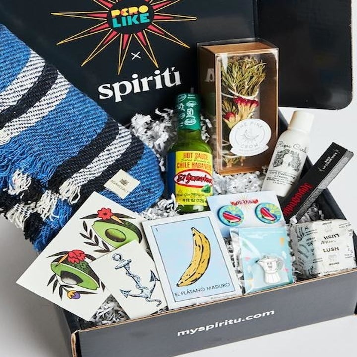 BuzzFeed Pero Like X Spiritú box full of hot sauce, a shawl, curl cream, a cafe bustello pin, Lush brand soap, sage, avocado temporary tattoos, and lipstick. 