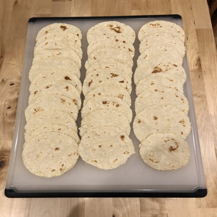 a cutting board filled with perfectly round tortillas