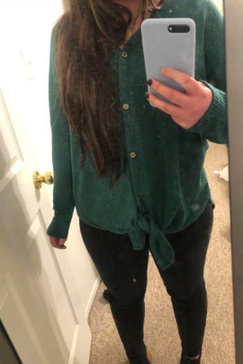 A reviewer wearing the top in green