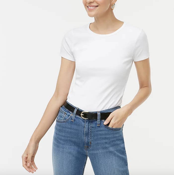A model wearing the tee in white with jeans