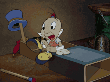 A gif of Jiminy Cricket taking his shoes off and getting into his bed