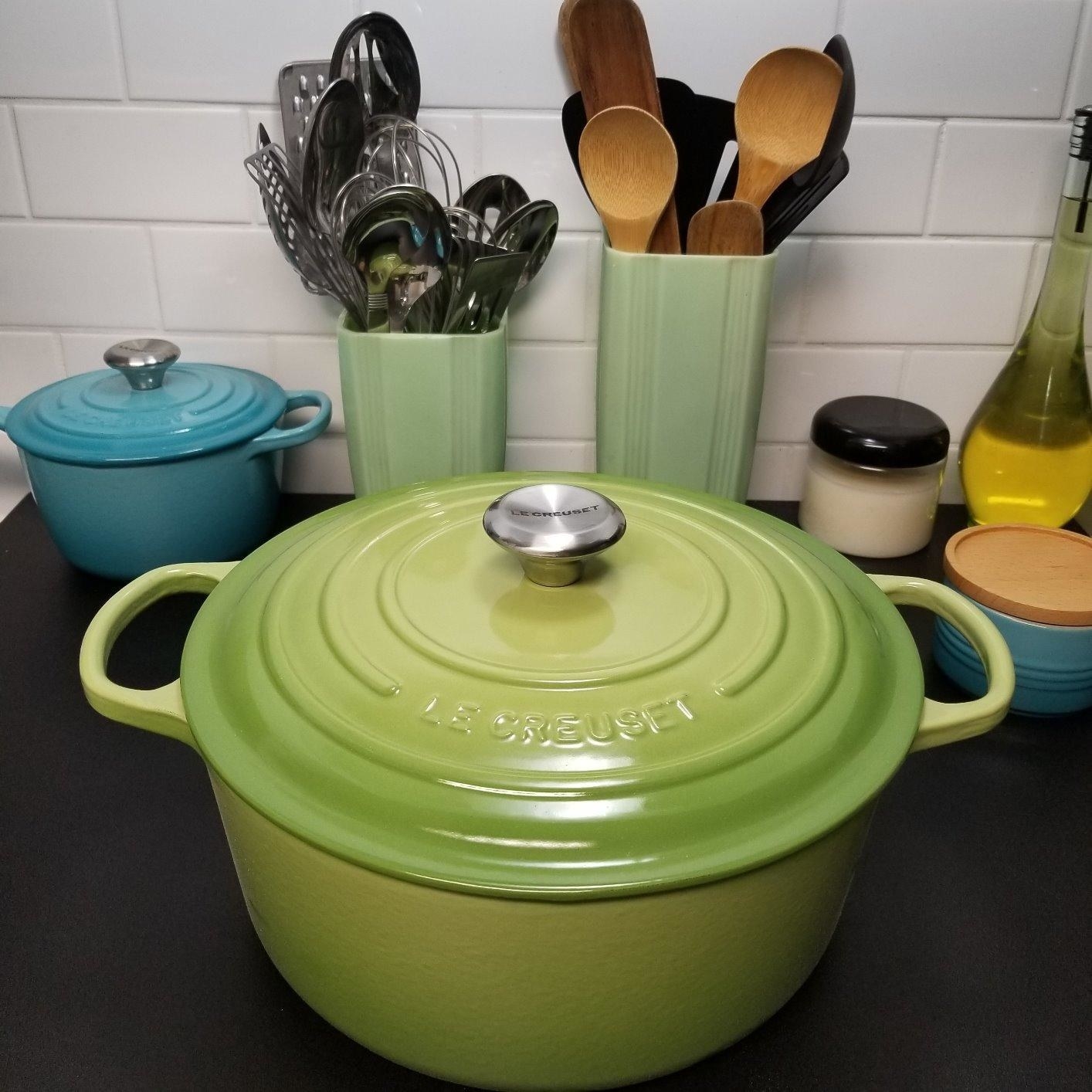 A lime green colored Dutch oven with its lid on sitting on a countertop 
