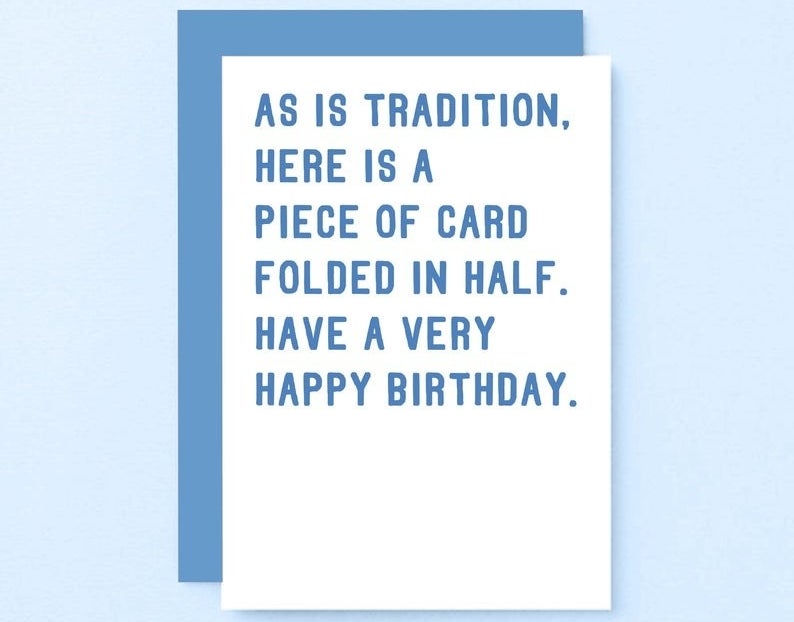 A white card with blue text that reads &quot;As is tradition, here is a piece of card folded in half. Have a very happy birthday&quot;