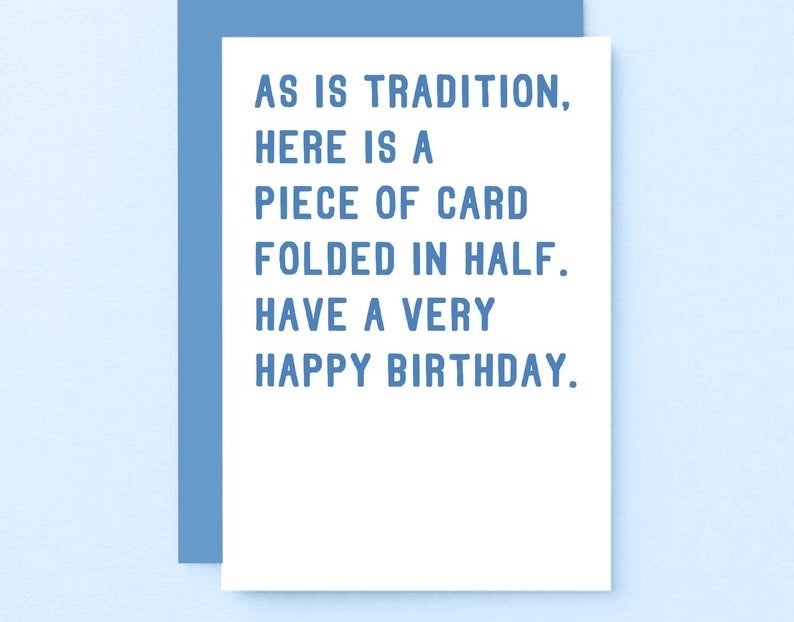 A white card with blue text that reads "As is tradition, here is a piece of card folded in half. Have a very happy birthday"