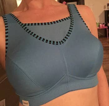 reviewer with a smaller bust wearing the  same bra in a darker gray