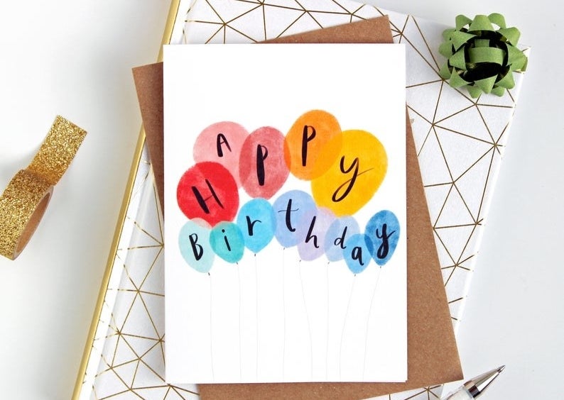 A card that reads &quot;Happy birthday&quot; on colorful watercolor balloons 