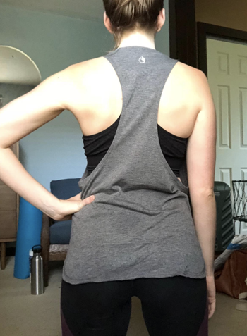 A reviewer in the gray version showing the deep racerback cut from behind