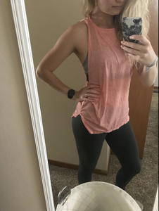 A reviewer in a pink tank that falls mid-bottom and has a crewneck 