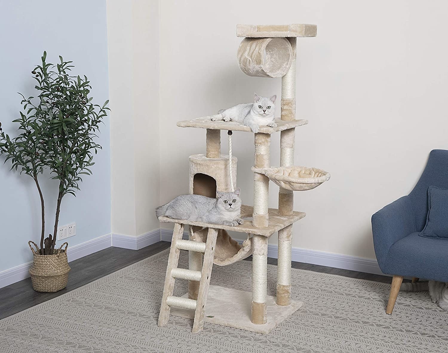 A product shot of a multi-level beige carpeted cat tower with stairs, pouches to sleep in, sisal leg posts to scratch, and nooks to explore