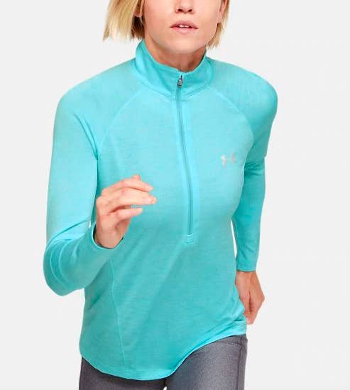 Woman running in the teal-colored version of the half-zip