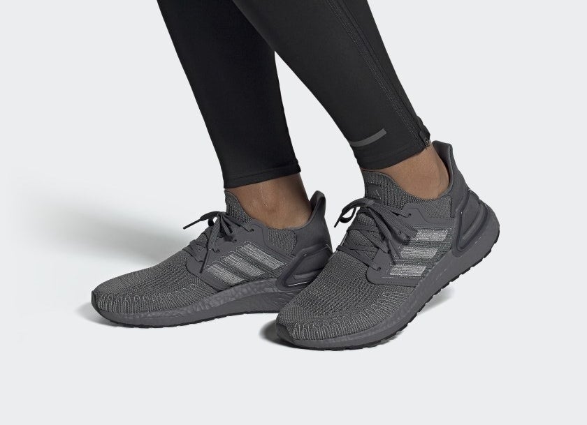 A pair of monochromatic gray sneakers worn with leggings