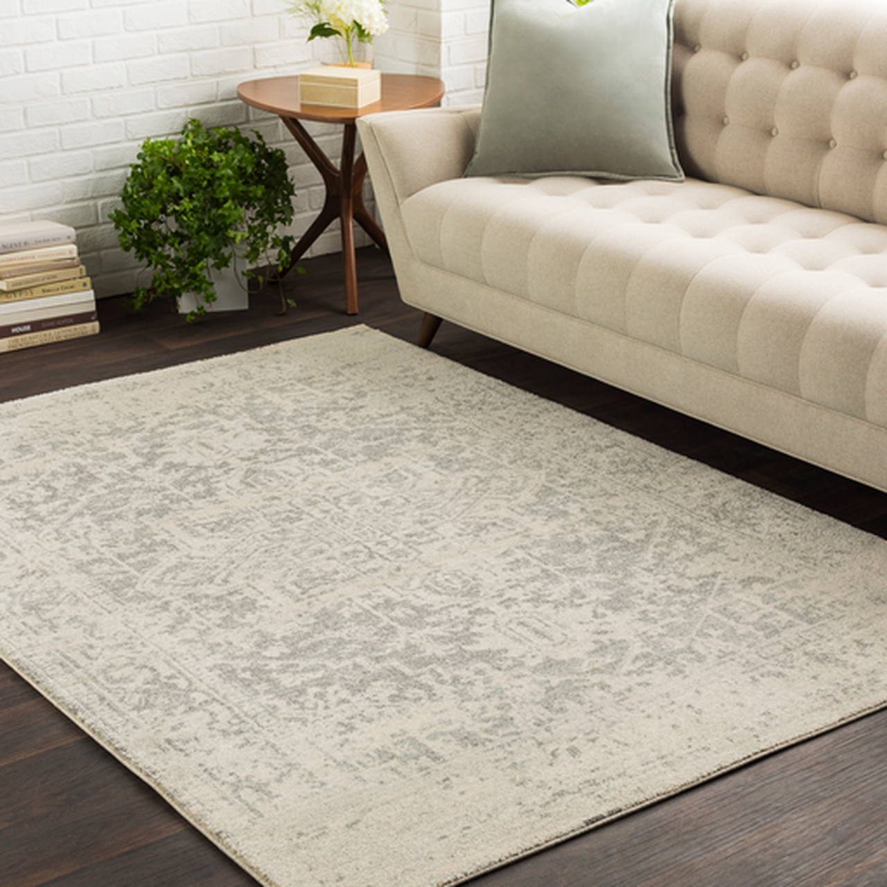 A neutral-color rug on a hardwood floor in front of a matching couch