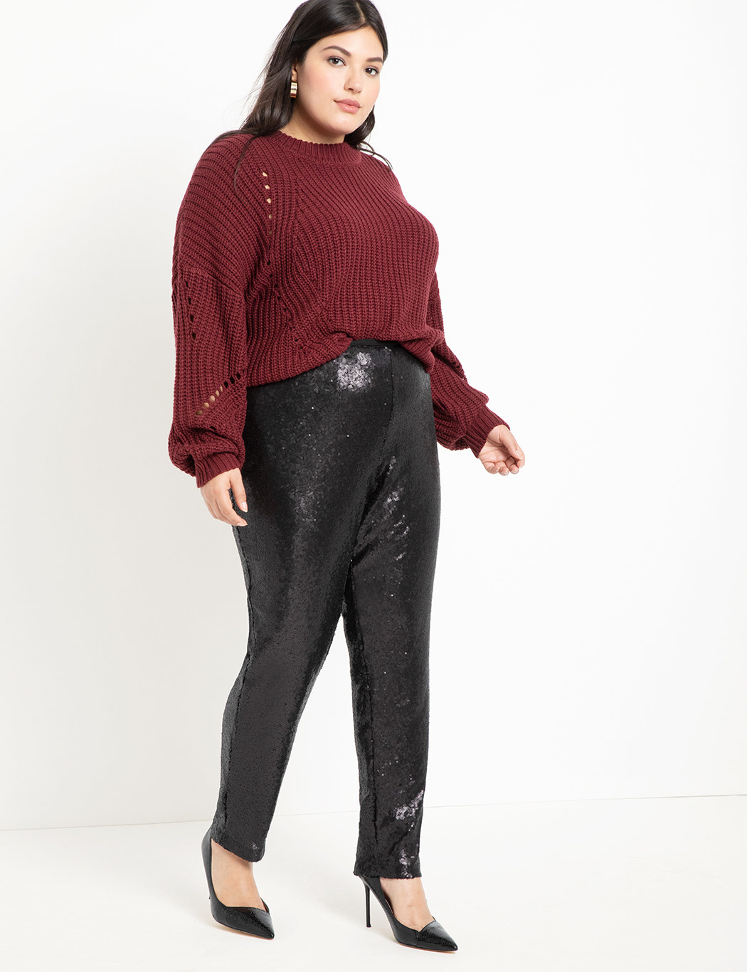 A model wearing the pants with a sweater and closed, pointed-toe heels