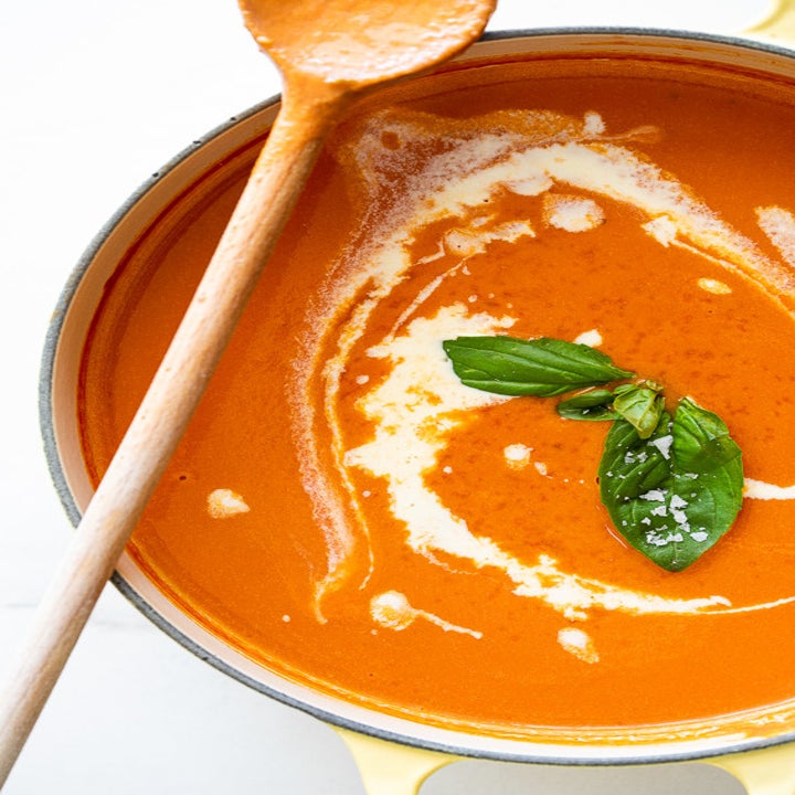 A big pot of creamy tomato soup with basil.