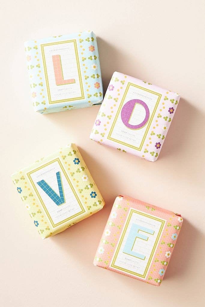 A set of four bar soaps wrapped in packaging that spells out the word love