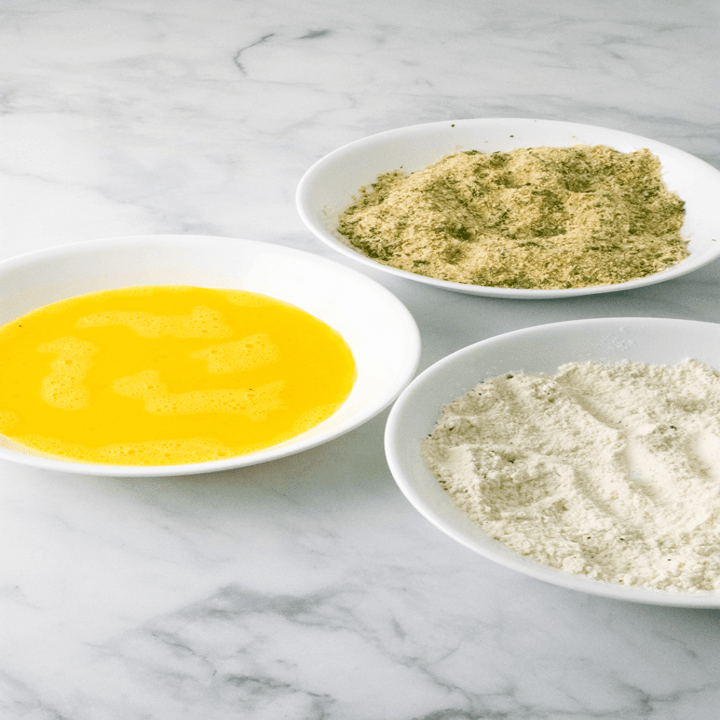 Egg, flour, and breadcrumbs in small bowls.