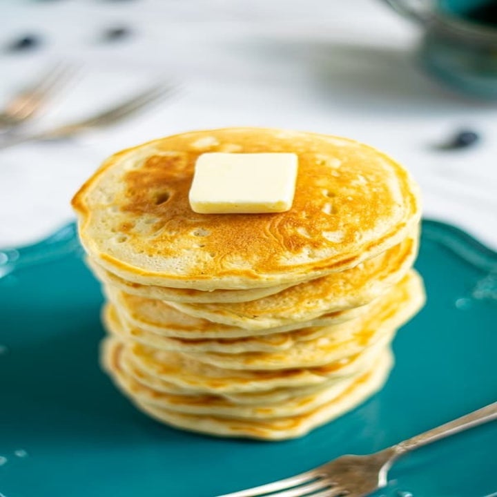 A stack of pancakes with butter on top.
