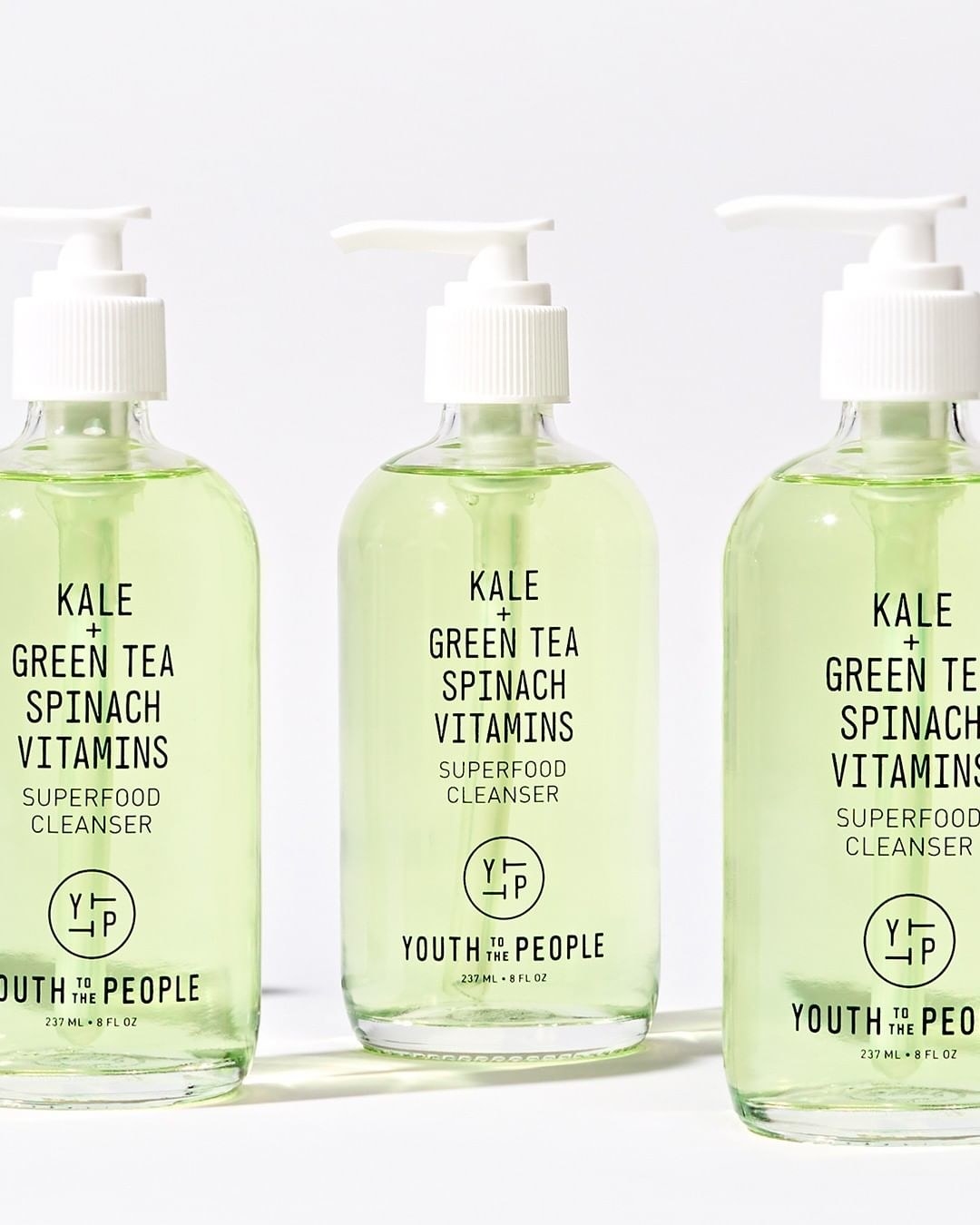 Three bottles filled with the light green cleanser — the bottles have a pump top