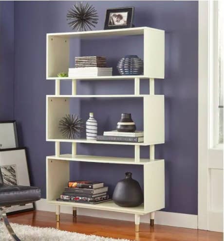 antique white bookcase with three stacked horizontal triangle compartments