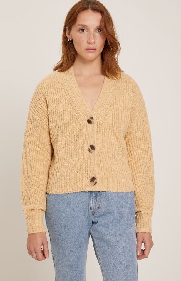 model in honey yellow v-neck ribbed cardigan with three large buttons styled with lgiht wash mom jeans