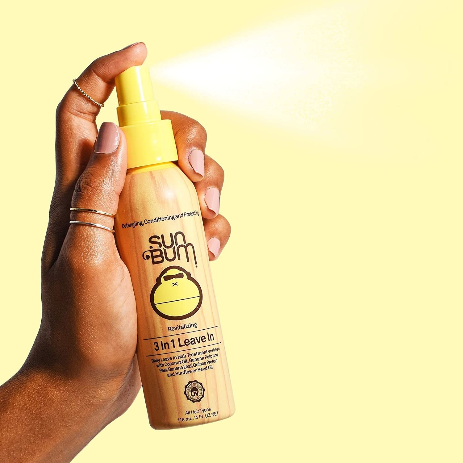 hand holding bottle with yellow spray nozzle labeled &quot;sun bum&quot; 