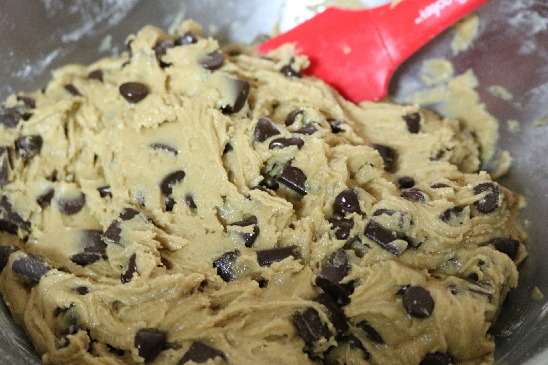 A close-up of the dough with chocolate chips and chocolate chunks incorporated throughout