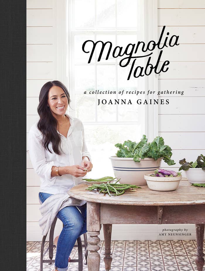 A cookbook cover showing HGTV star and author Joanna Gaines sitting at a table full of vegetables smiling