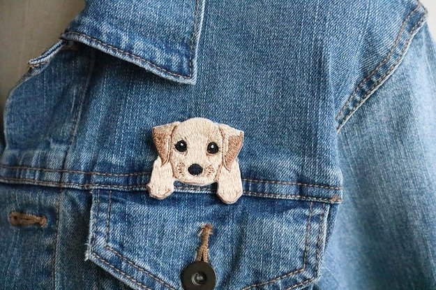 an iron-on patch of a pale colored puppy with big eyes seeming to hang over the pocket of a denim jacket