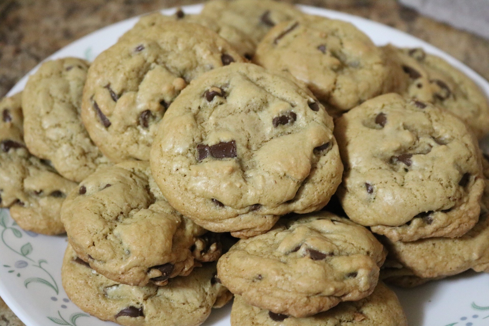 A plate full of fully baked cookies piled on top of each other