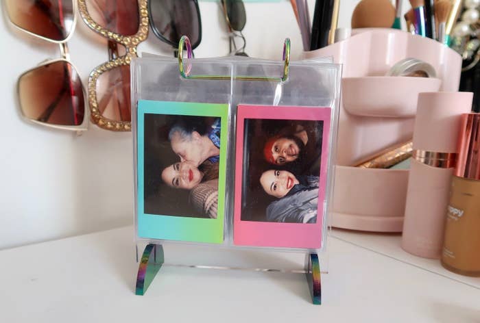 A photo flip book sitting on a vanity with a couple of family photos on display