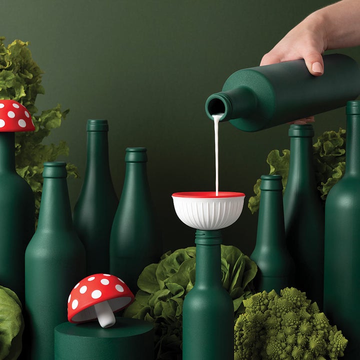 A person pouring liquid into the mushroom-shaped funnel