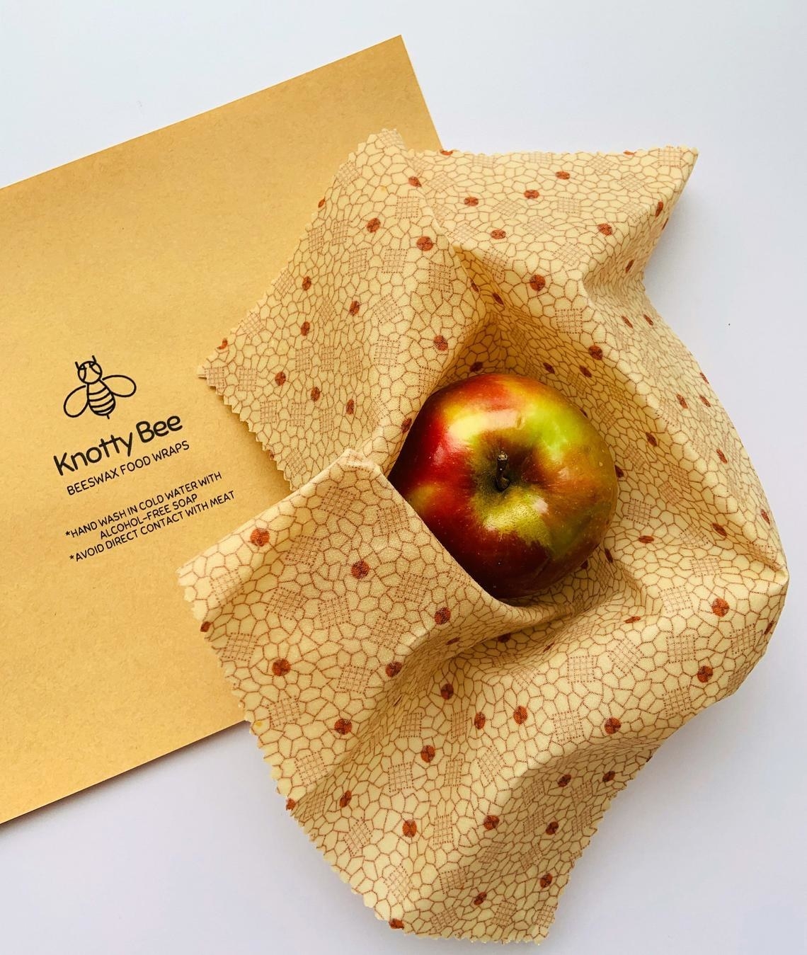 An apple nestled in beeswax wrap with a geometric pattern 